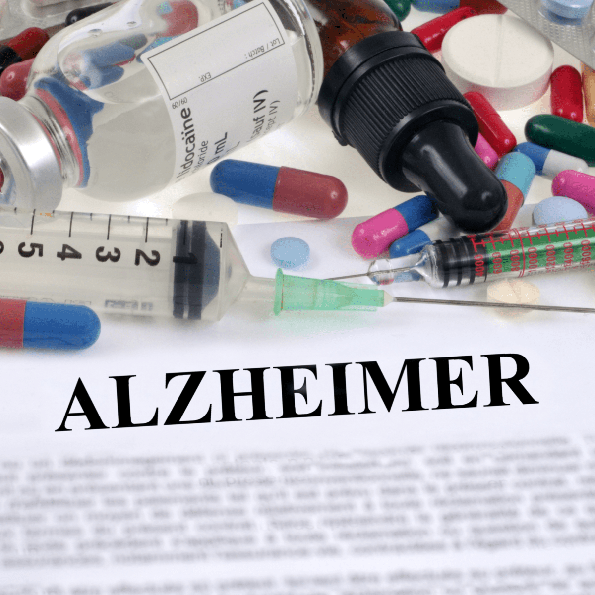 Syringes and pills with the word Alzheimer in bold text